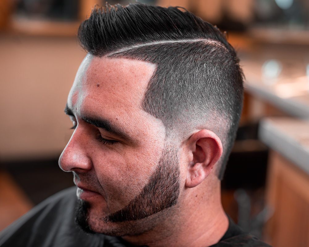 Sharp side part fade with a crisp beard line at Choppers Barbershop